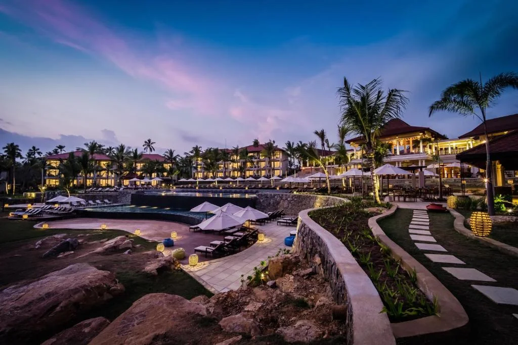 Evening view of tranquil reflection pool and seaside palms at Anantara Peace Haven