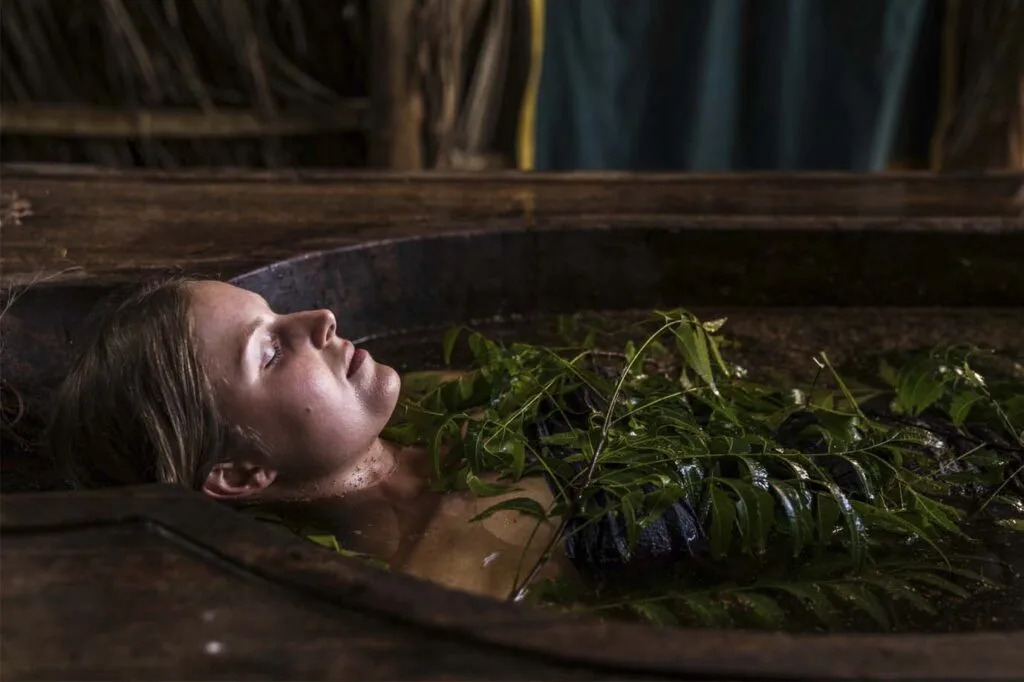 Therapeutic herbal and flower petal bath in stone tub