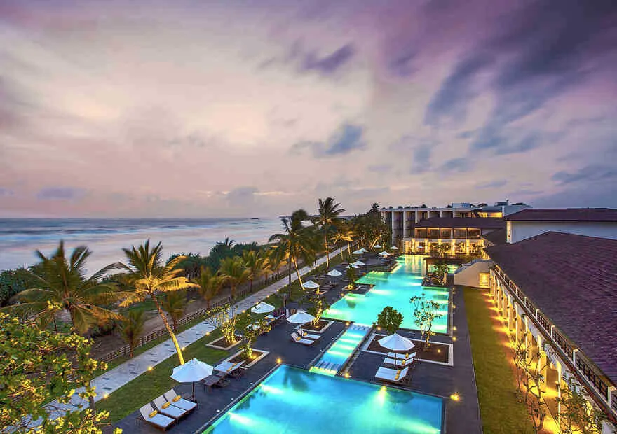 Illuminated night aerial view of Centara Ceysands Resort nestled between river and sea