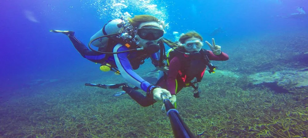 Couples deep-sea scuba diving along the coral reefs of Hikkaduwa