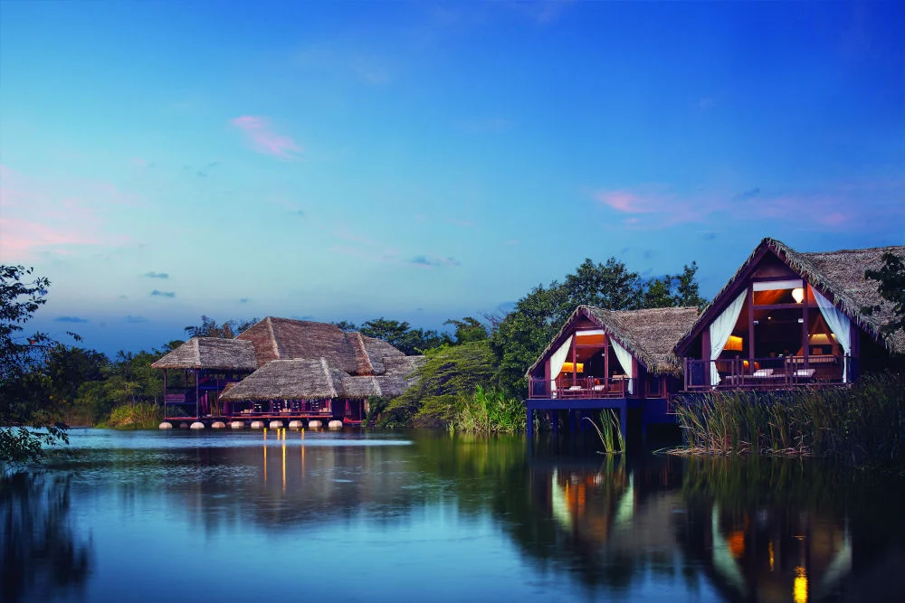 Twilight view across man-made wetland dwellings at Jetwing Vil Uyana
