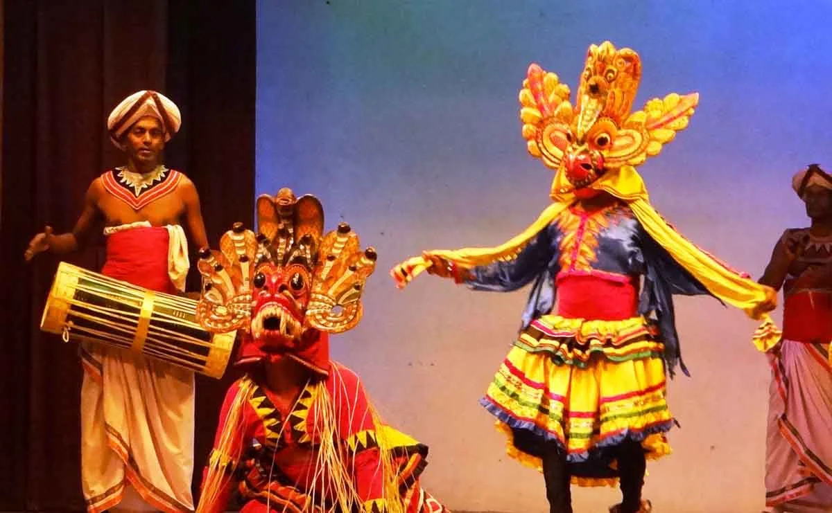 Traditional Kandyan masked dancers and drummer performing in full ceremonial regalia