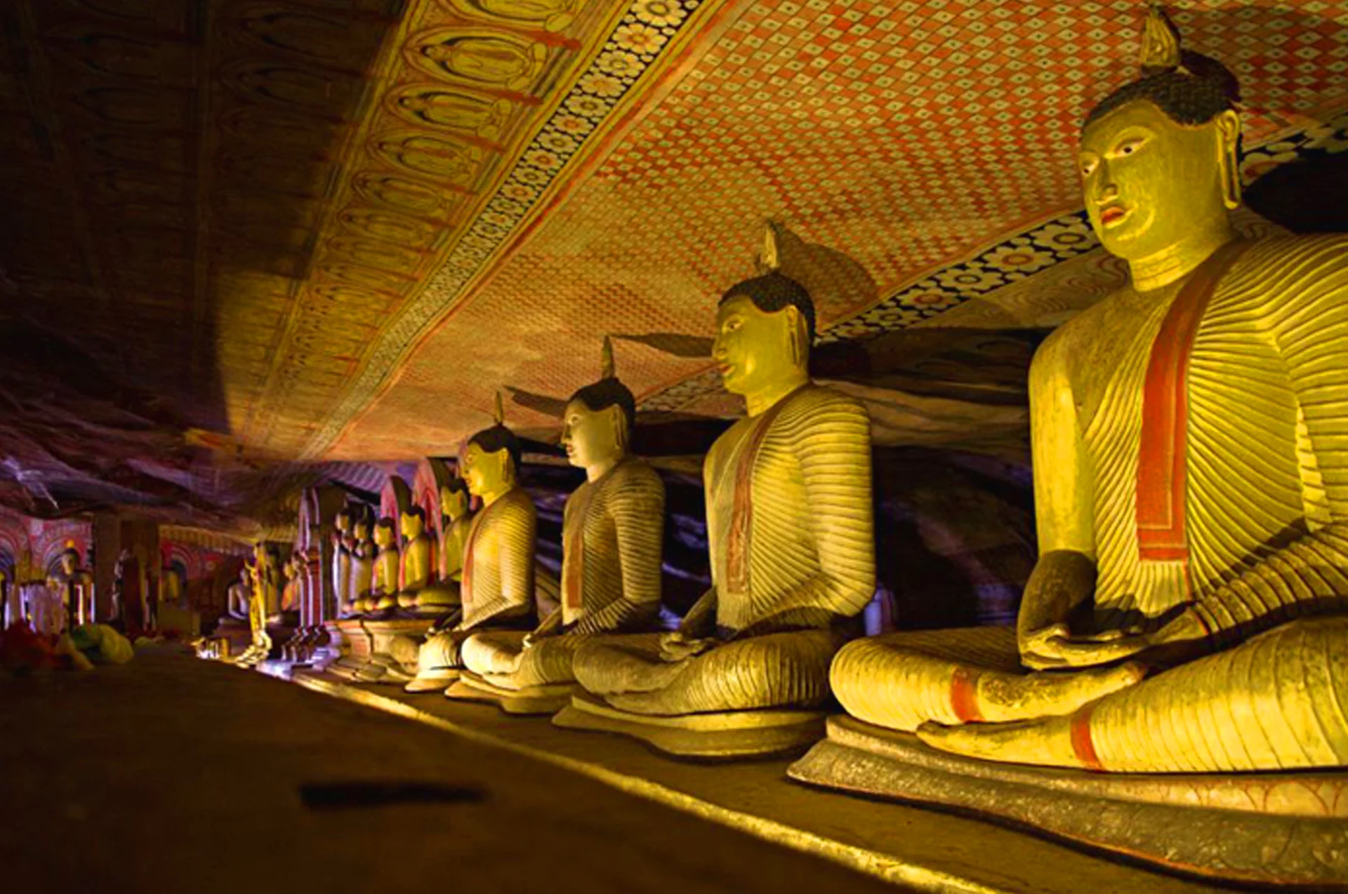 The Maha Aluth Viharaya cave with seated Buddha sculptures and Kandyan period murals