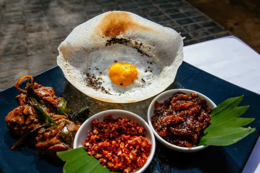 Crispy Sri Lankan hoppers (appa) served with spicy lunu miris and curry