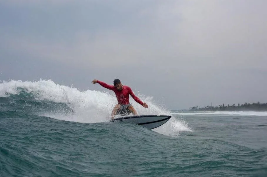 Surfer carving on a peeling reef break in Ahangama