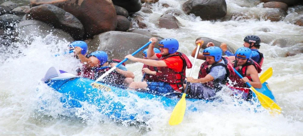 Adventurous rafters navigating Grade 3 whitewater rapids on the Kelani River in Kitulgala