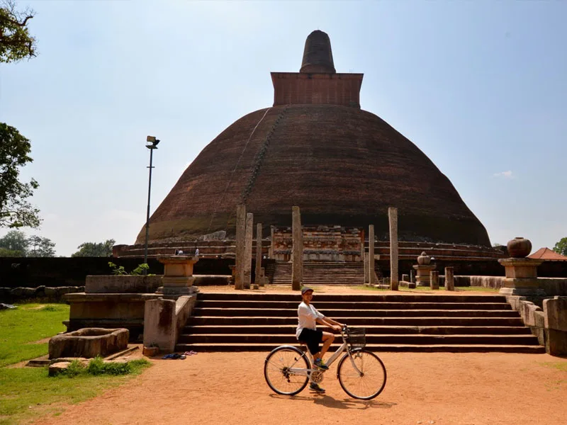 Cycling along tree-lined shaded paths through the ancient city of Anuradhapura
